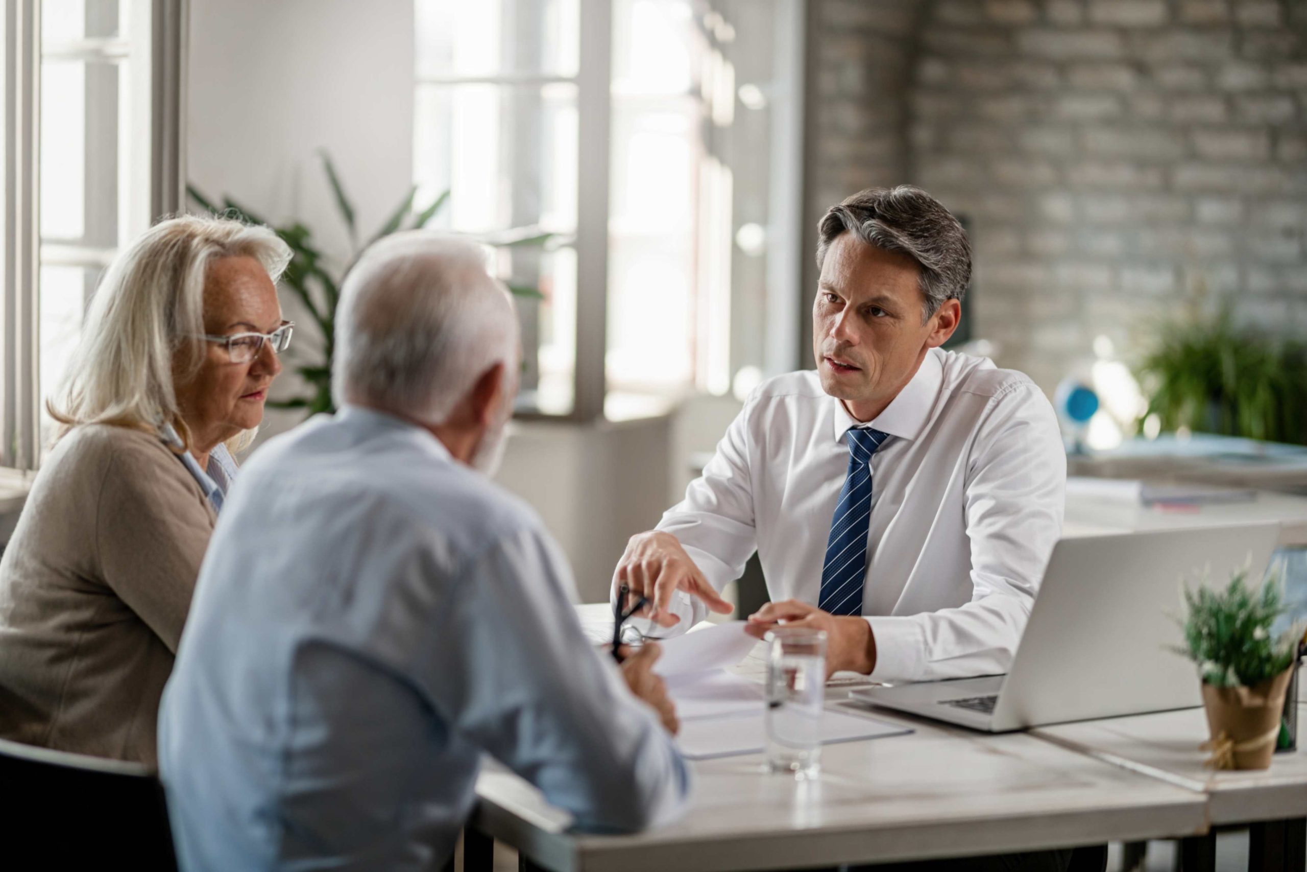 jpeg optimizer mid adult insurance agent with mature couple analyzing financial reports communicating meeting office scaled